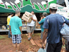 Descarregamento das doações do bagageiro do ônibus para a nave da igreja