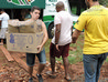 Descarregamento das doações do bagageiro do ônibus para a nave da igreja