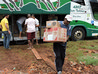 Descarregamento das doações do bagageiro do ônibus para a nave da igreja